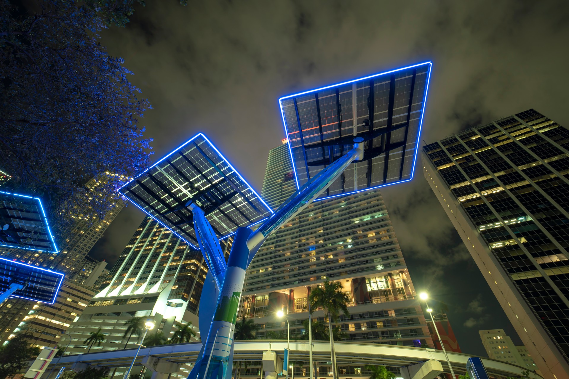 Urban street neon illumination with solar photovoltaic panels for power supply of streetlights and surveillance cameras. Futuristic energy source in downtown Miami, Florida